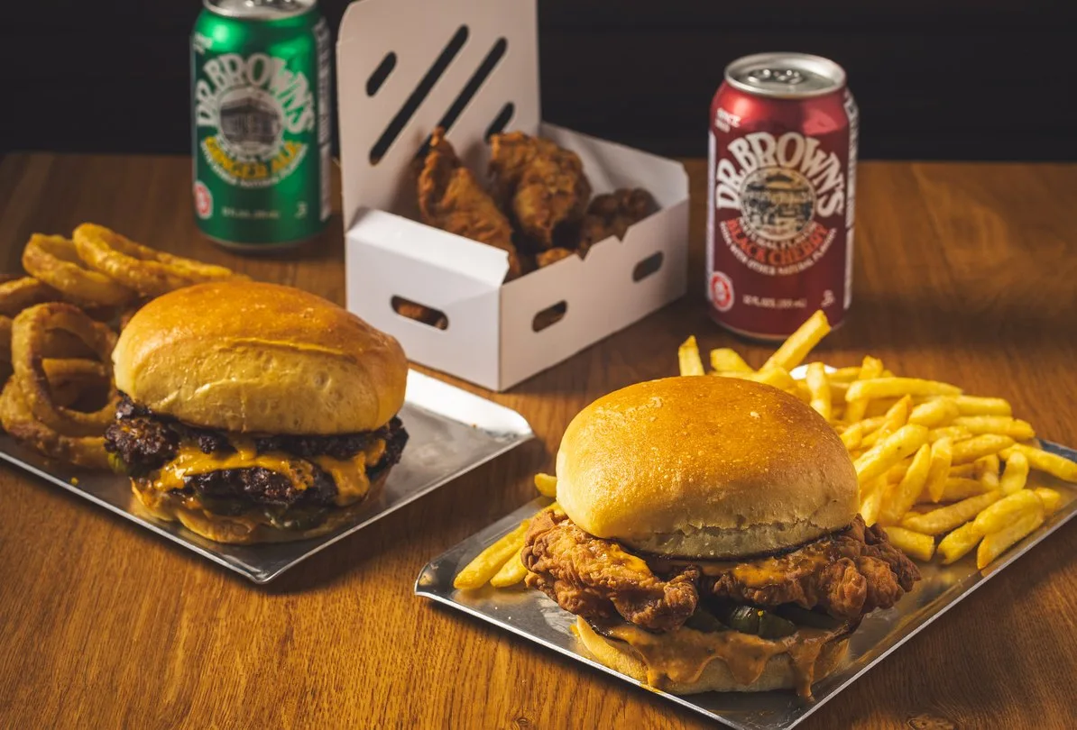 Burger and crispy chicken sandwich with fries and onion rings
