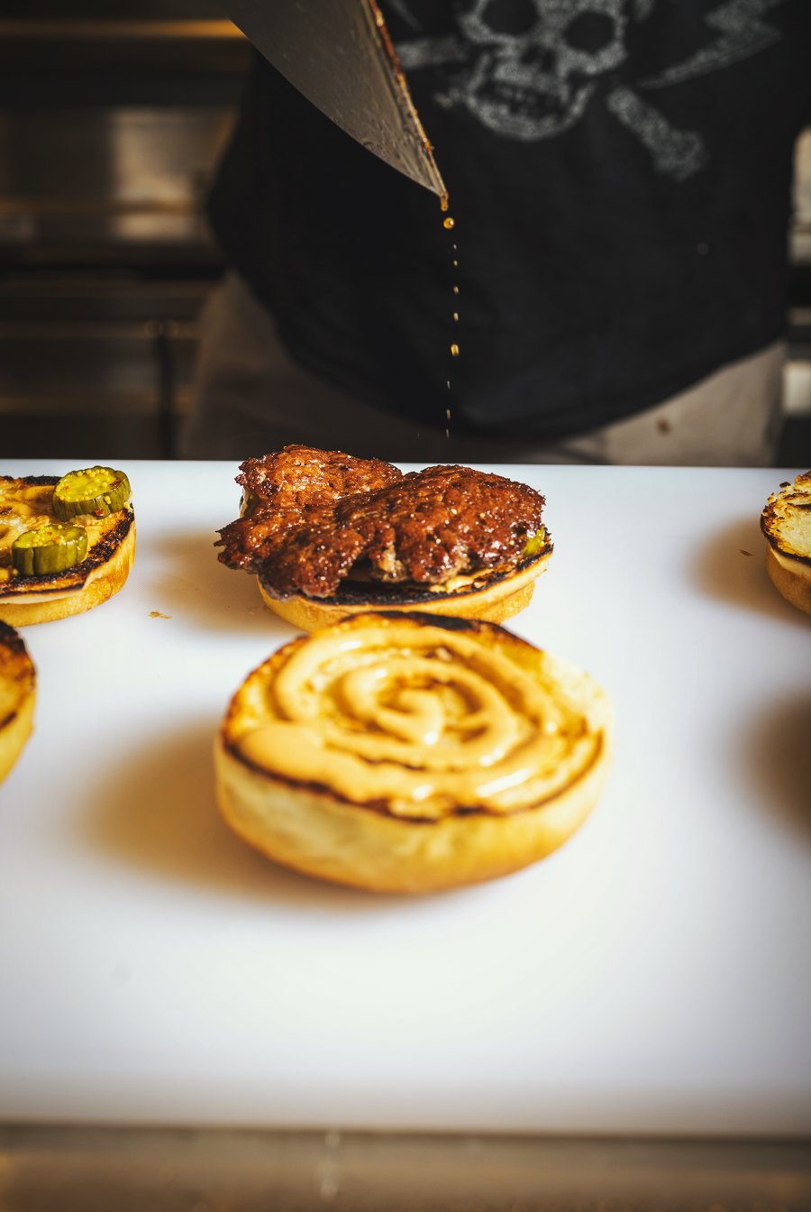 Sauced buns with pickles and a beef patty